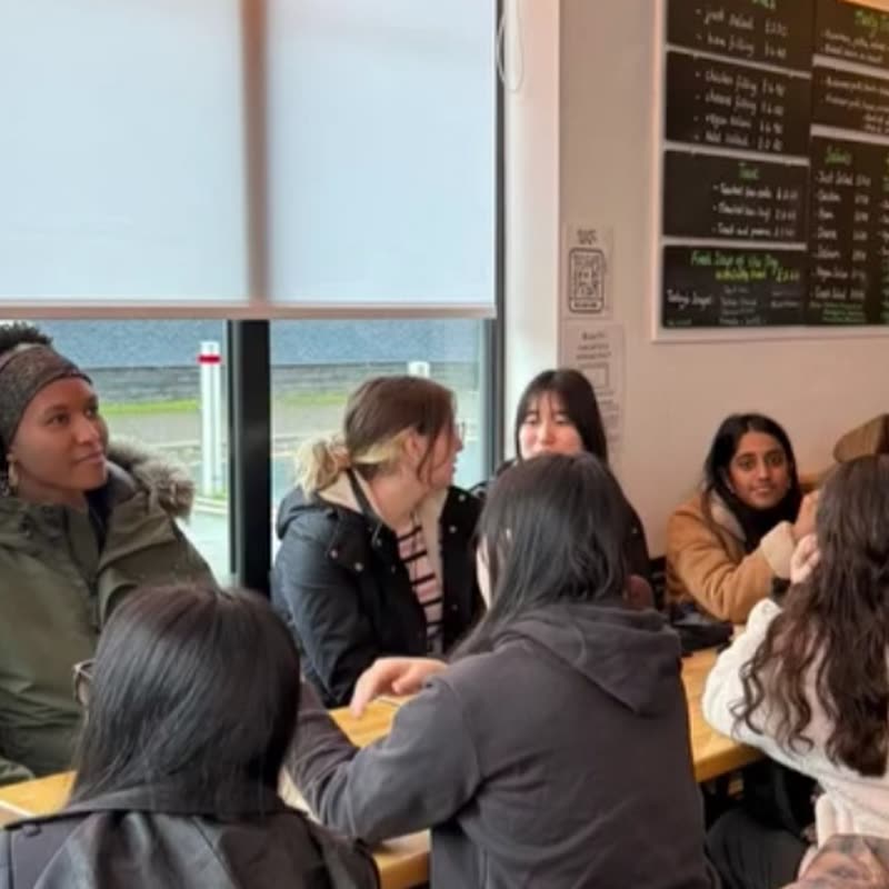 Members chatting around a long table in a cafe on the matcha crawl.